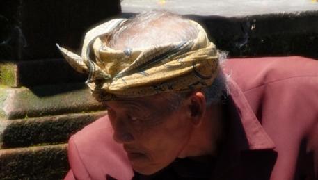 Bali - un fedele raccoglie acqua dalla sacra fonte al Tempio Tampaksiring